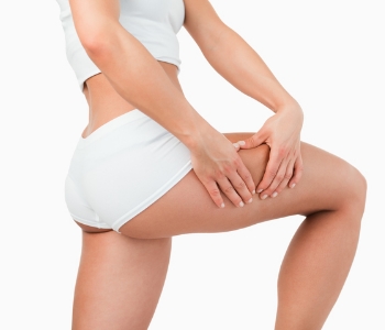woman holding her thigh after cellulite treatment